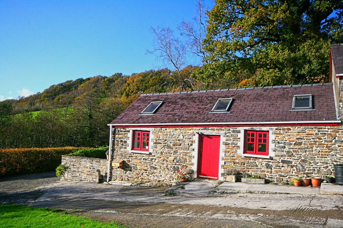 The front of the barn with red door and windows
