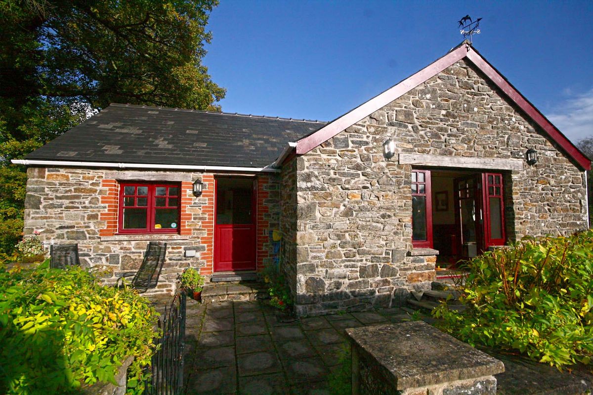 The barn's stone exterior with its sunny patio and planting